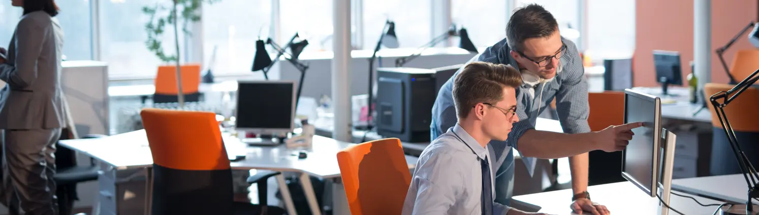 Zwei Männer arbeiten an einem Computer im Büro