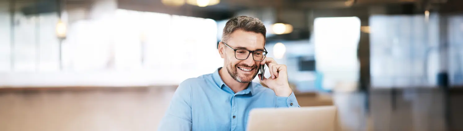 Ein Mann telefoniert mit seinem Handy vor verschwommenem Hintergrund