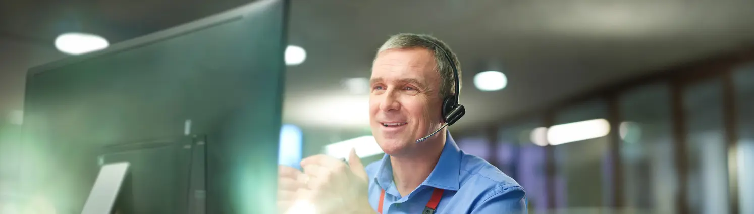 Ein Mann mit Headset telefoniert im Kundenservice