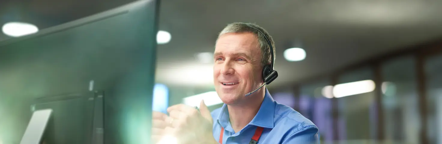 Ein Mann mit Headset telefoniert im Kundenservice